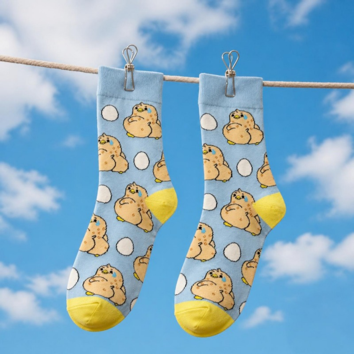 Awkward Ducky Socks hanging on a clothesline against a blue sky