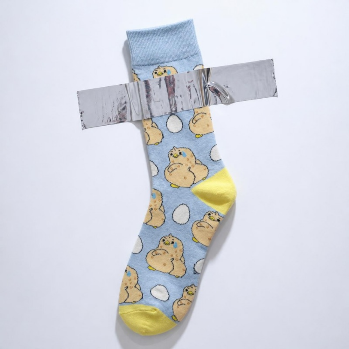 Awkward Ducky Sock taped to a white wall